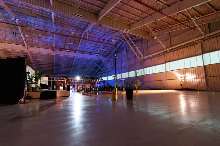 The hangar at dusk, banner displays glowing down its length