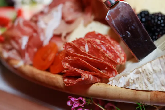 Close detail of the board — prosciutto, berries and dried apricot
