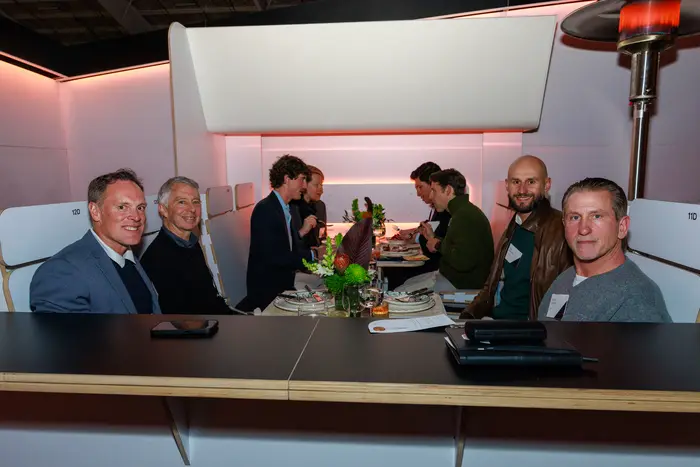 A table of guests in conversation over dinner in the cabin