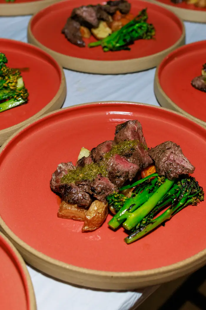 The main course plated on terracotta — beef, asparagus and confit tomato