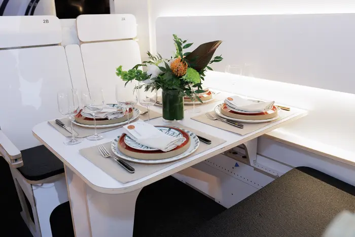 A table inside the cabin mockup set for dinner, florals and folded linen under warm light