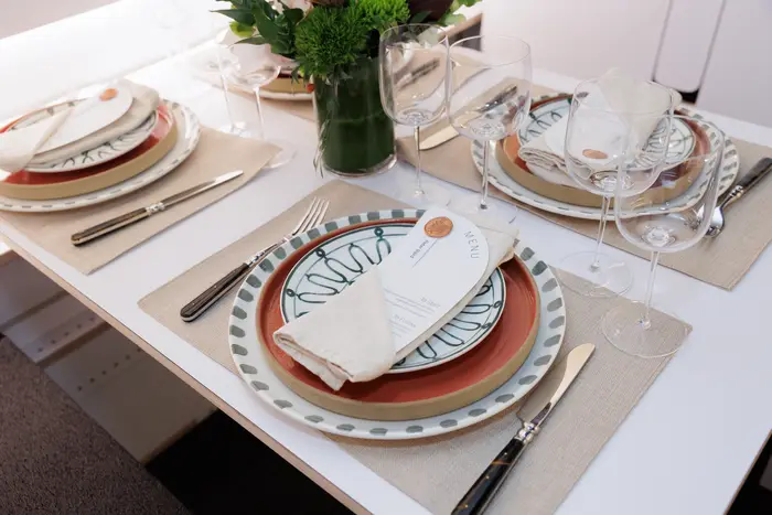 Place settings on the white composite cabin table, patterned plates and glassware