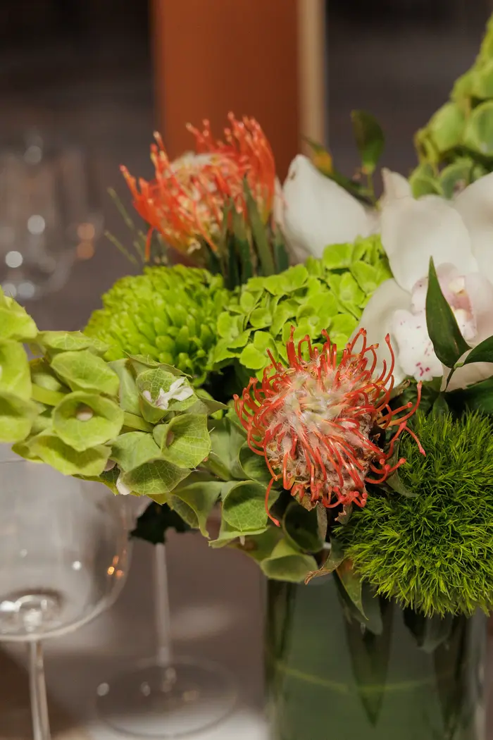 A low floral arrangement in protea and greenery on the cabin table