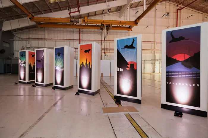 The full run of illuminated panels down the hangar, floor reflecting the light