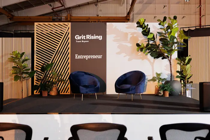 The Grit Rising stage set with two armchairs and the Entrepreneur backdrop