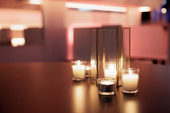 Votive candles clustered on a bar top before doors