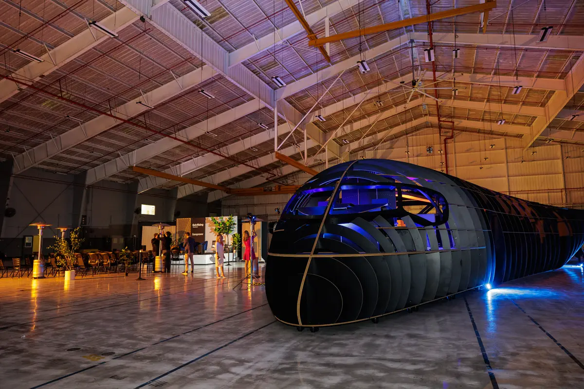 The full-scale blended-wing cabin mockup lit blue inside the JetZero hangar