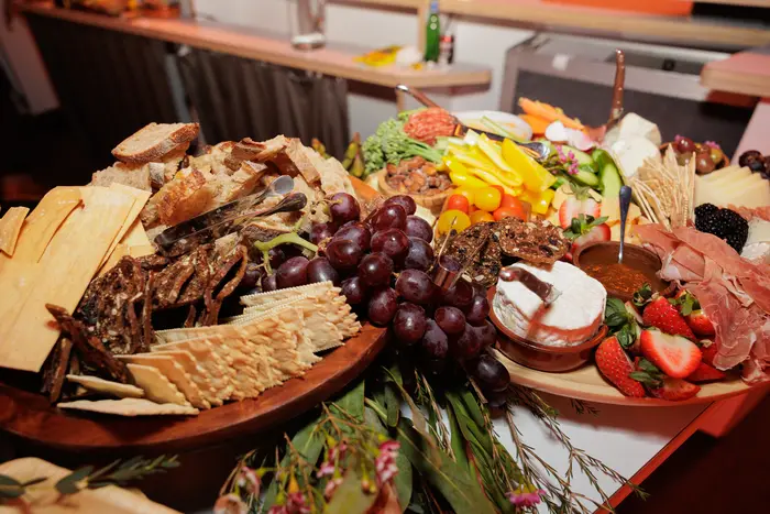 A charcuterie board built along the bar, cheeses, fruit and crackers