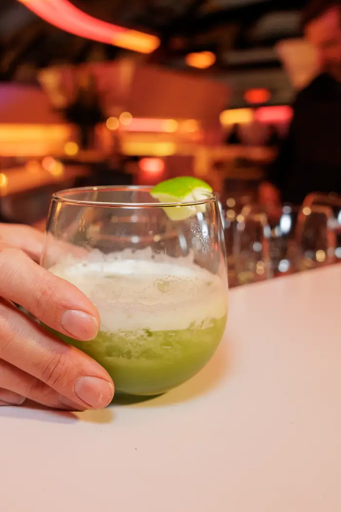 A cocktail in hand, lime and salt on the rim