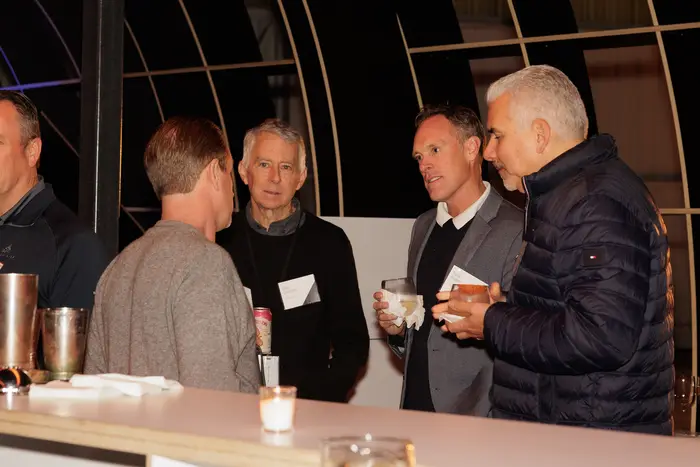 Two guests in conversation with the lit aircraft behind them
