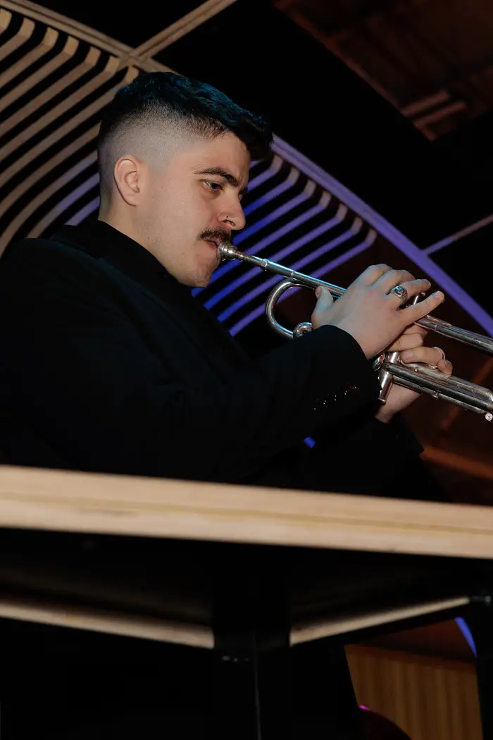 A horn player performing during the cocktail hour