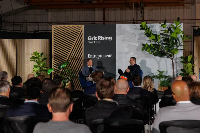 The audience filled in, the Grit Rising and Entrepreneur backdrop beyond them