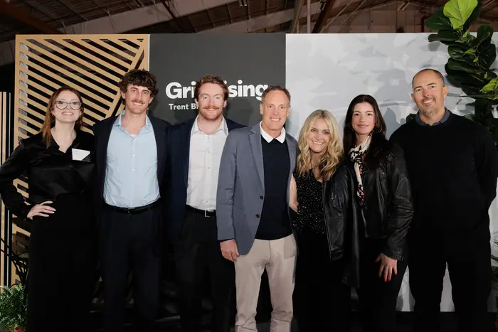 A group portrait at the Grit Rising backdrop