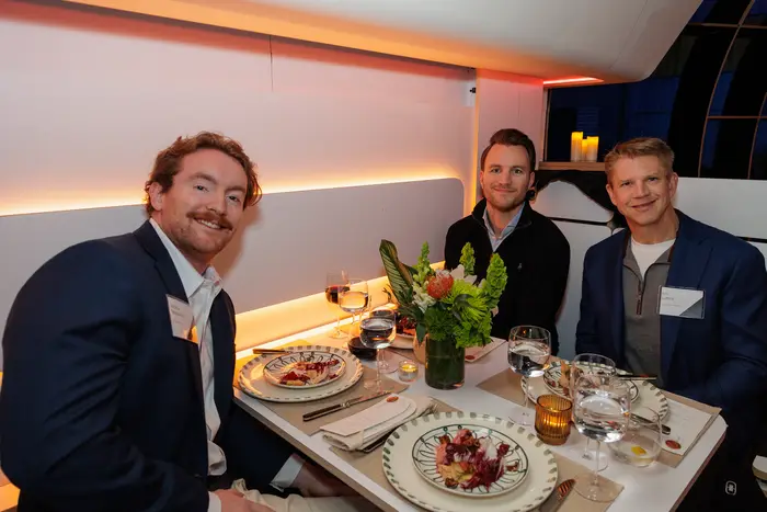 Guests at a cabin table, glasses raised mid-conversation