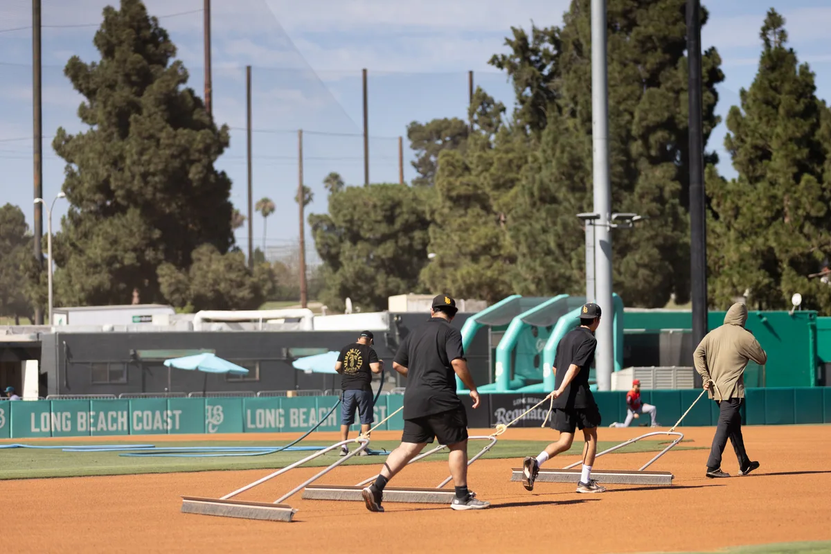 The infield drag seen wide, with the Long Beach Coast outfield wall behind