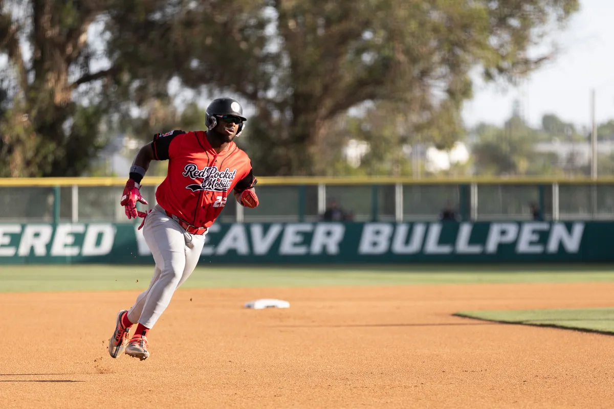 A runner rounds third past the Jered Weaver Bullpen sign