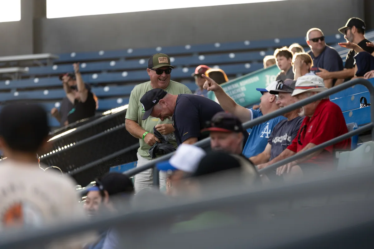 Spectators watching from the shade of the grandstand