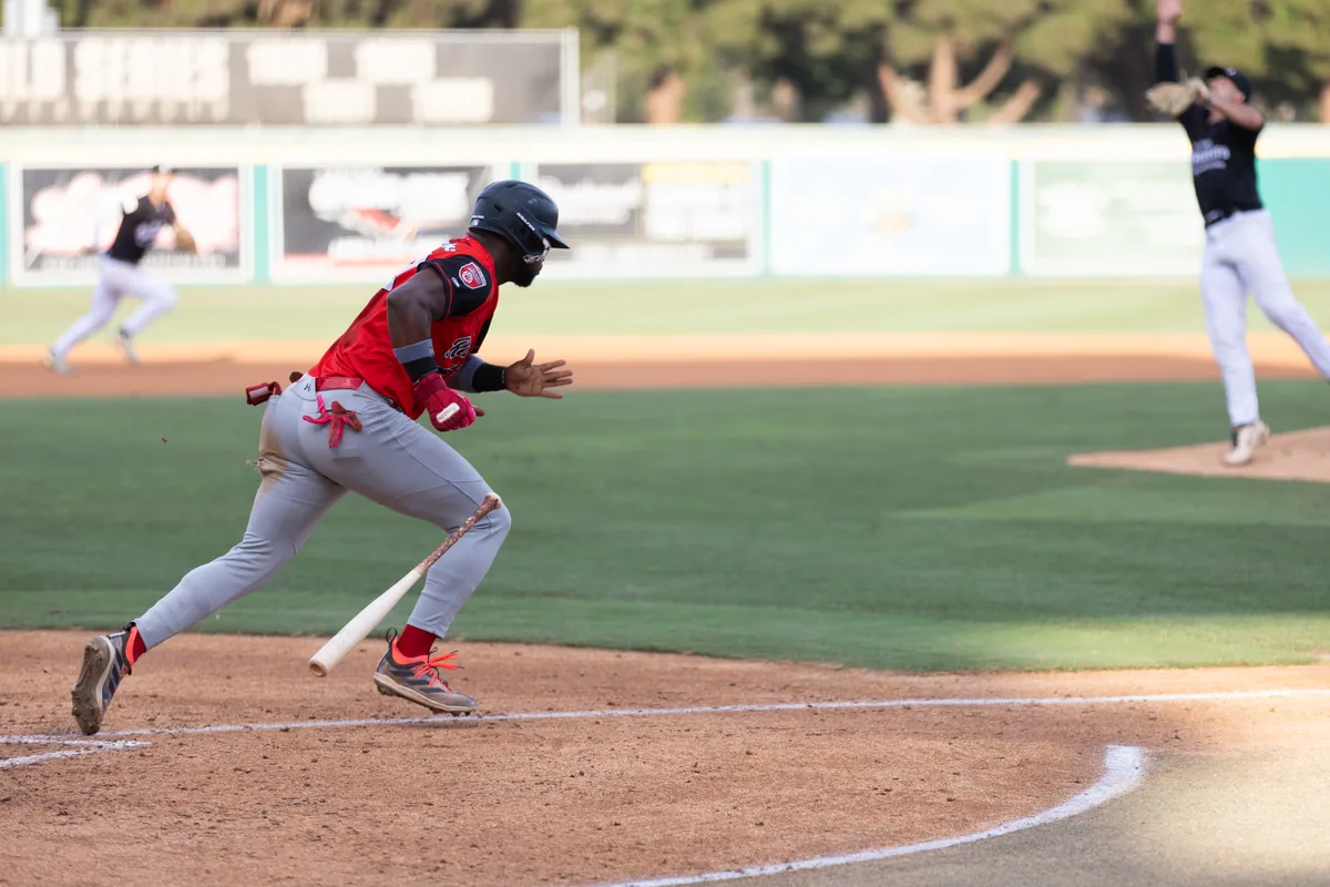 Number 22 running the bases in the red road uniform
