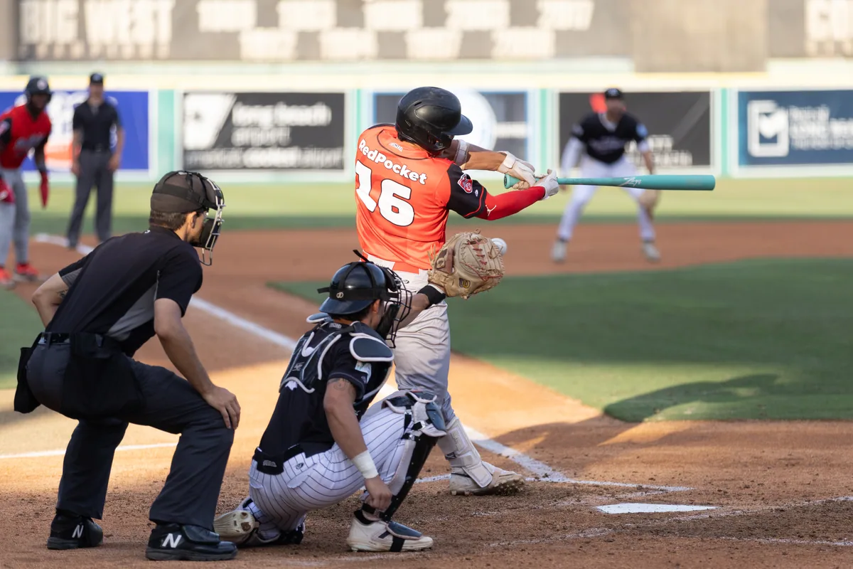 A runner slides into the plate as the catcher takes the throw
