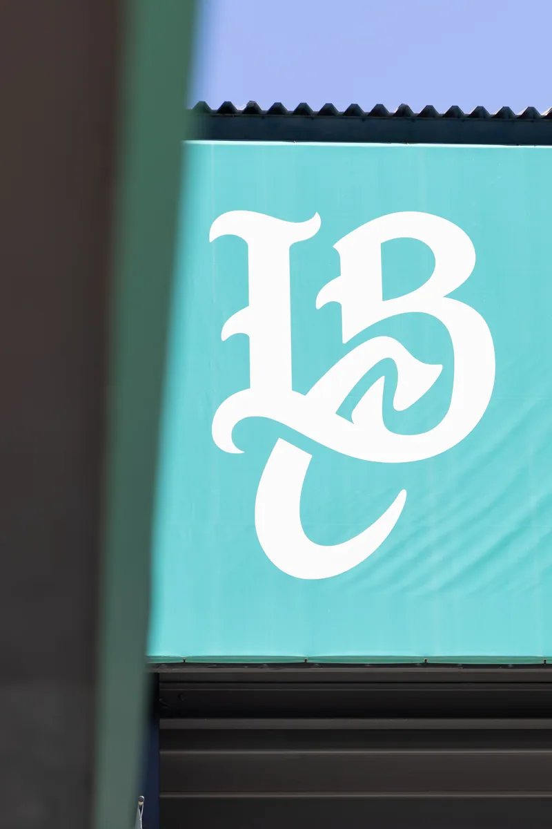 The Long Beach Coast roundel on teal padding behind home plate