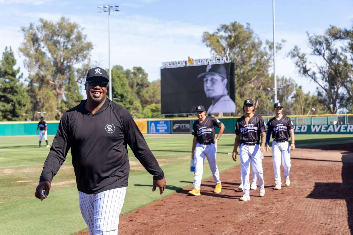 A coach walking the line as the team waits