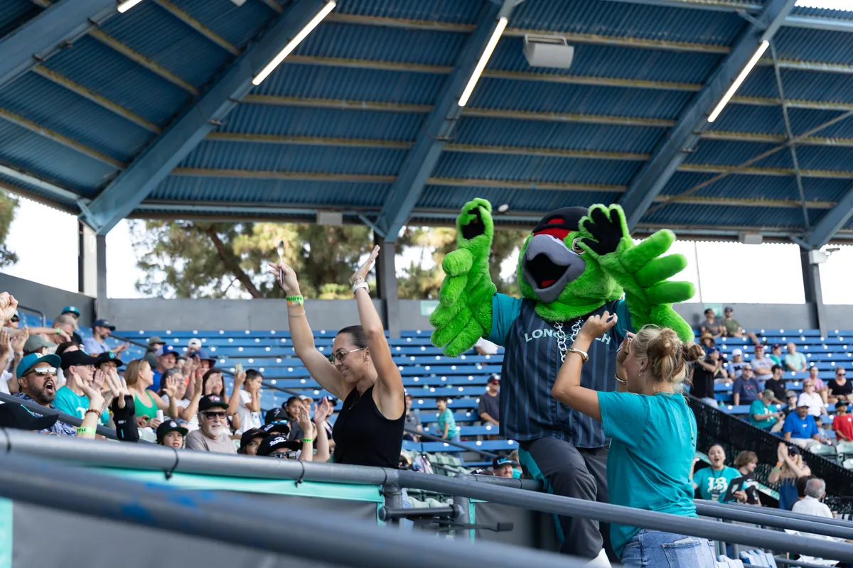 The mascot working the rows with fans reaching in