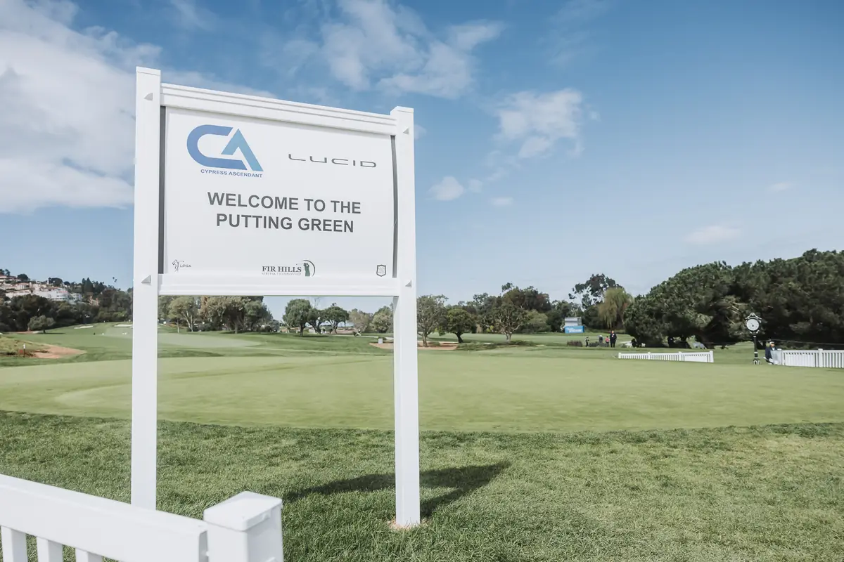 The WELCOME TO THE PUTTING GREEN board standing alone on the practice green before the first player arrives