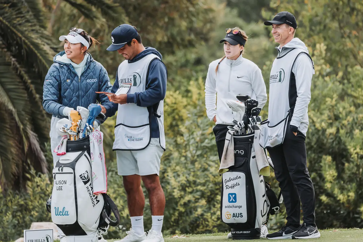 Two players and their caddies waiting with the bags on a tee at Palos Verdes Golf Club