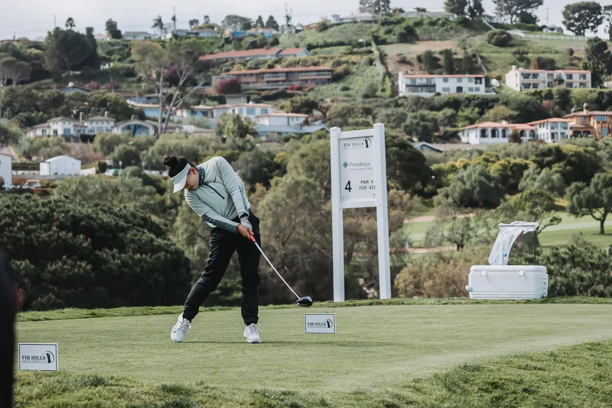 A tee shot at Palos Verdes Golf Club with the Peninsula hillside and its houses stacked behind the green