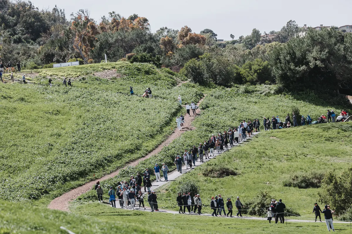 The gallery strung single file along a dirt path cut into the green hillside at Palos Verdes Golf Club