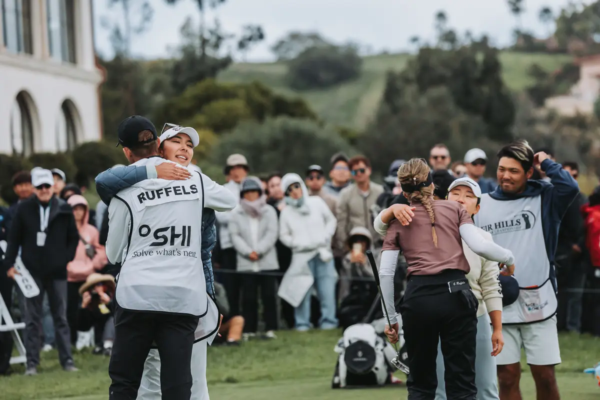 Players and caddies embracing as they come off the last green at Palos Verdes Golf Club