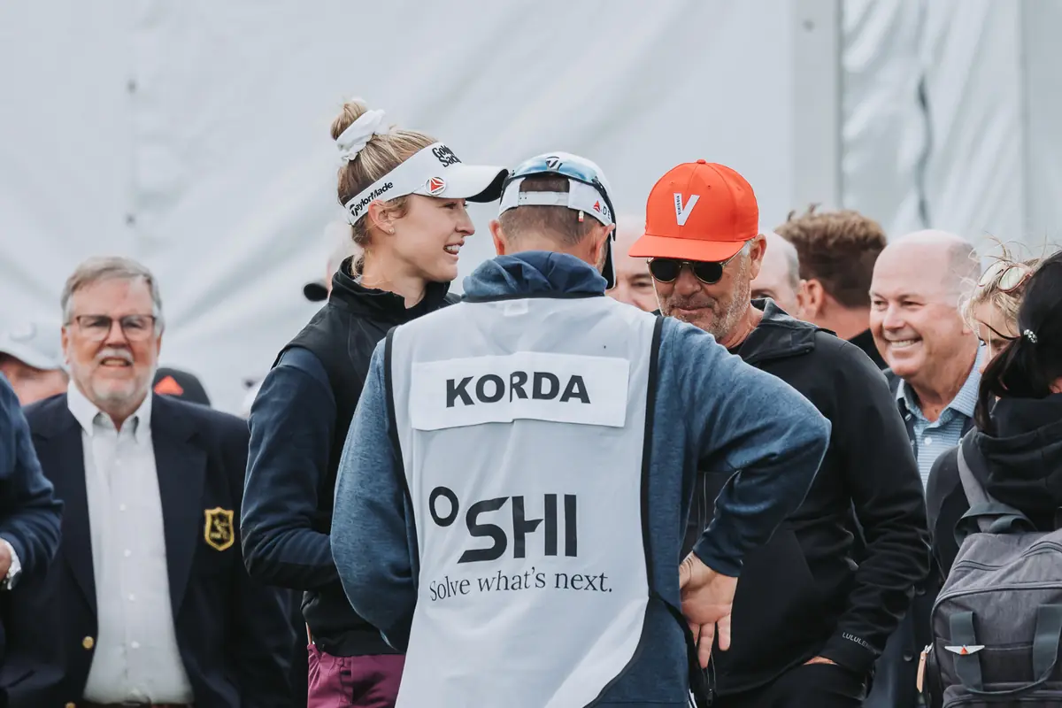The winner's caddie bib in the scrum of officials and family gathered behind the 18th green