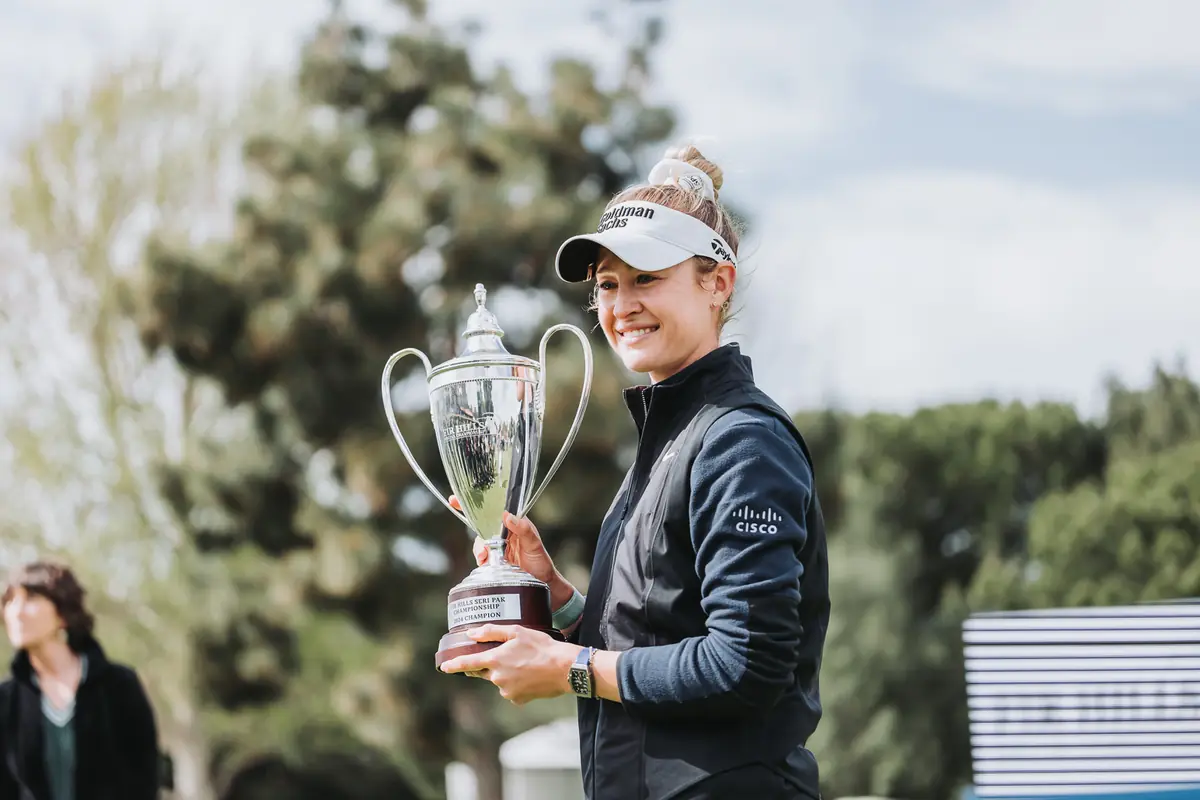 Nelly Korda holding the Fir Hills Seri Pak Championship trophy on the 18th green at Palos Verdes Golf Club