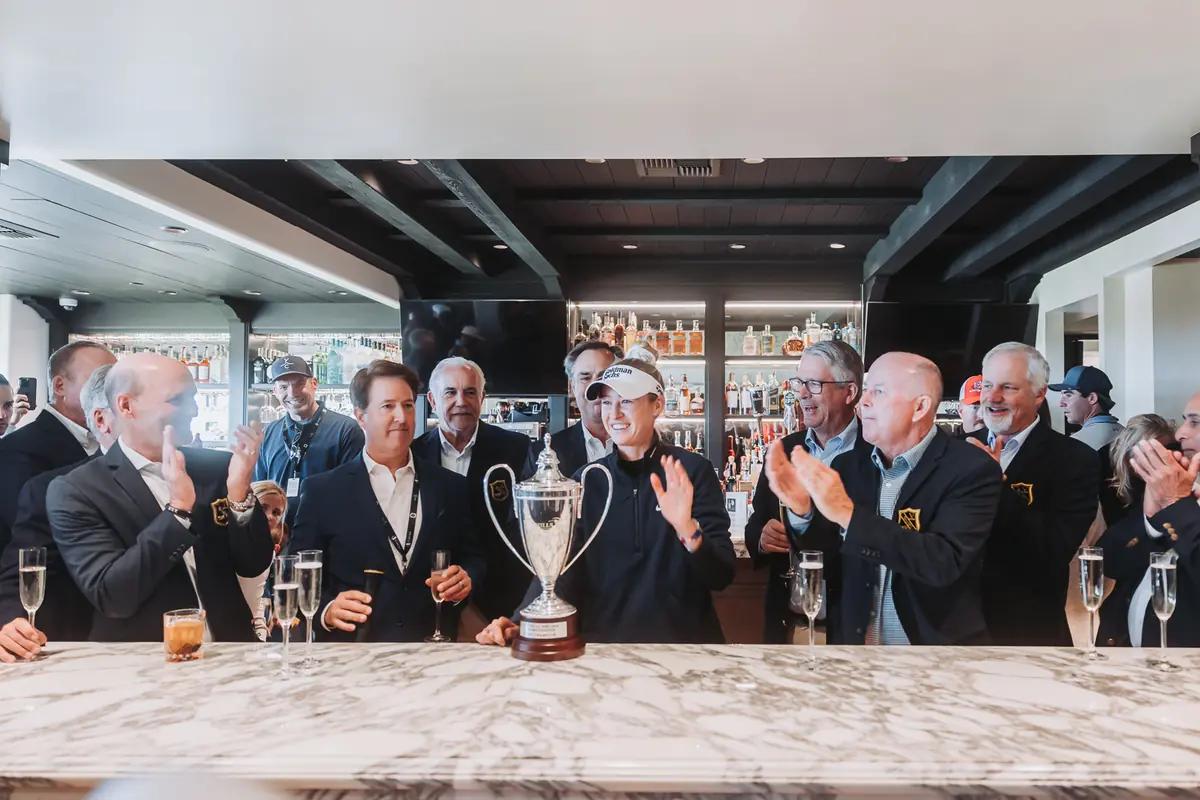 Palos Verdes Golf Club officials in club blazers gathered along the clubhouse bar with the championship trophy in front of them
