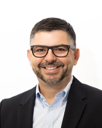 Team member in a dark blazer and pale blue shirt