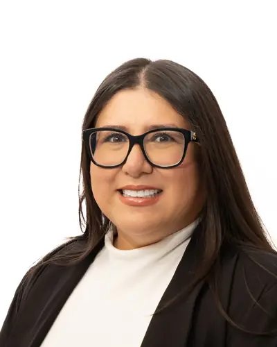Team member in a black blazer over a cream top