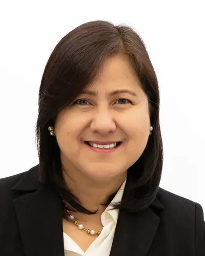 Team member in a black blazer and gold necklace