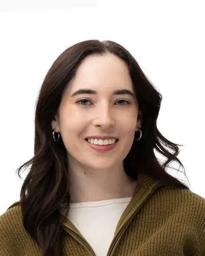 Team member in an olive zip-neck sweater