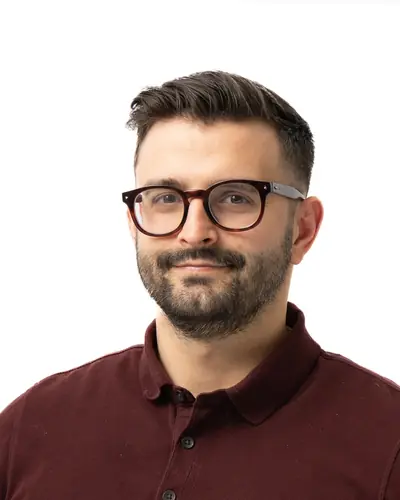 Team member in a burgundy polo and dark glasses