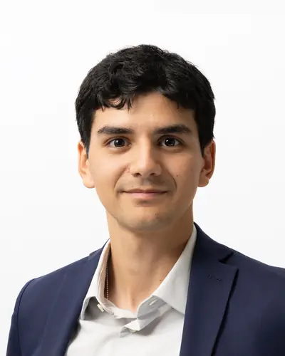 Team member in a navy suit and open collar