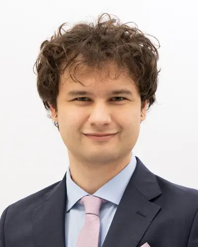 Team member in a charcoal suit and pale tie