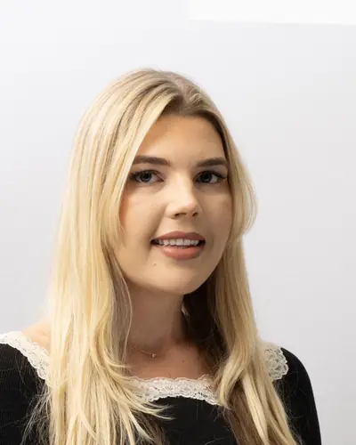 Team member in a black top with a lace collar