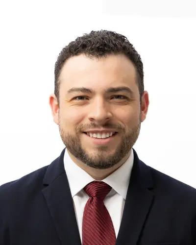 Team member in a dark suit and red tie