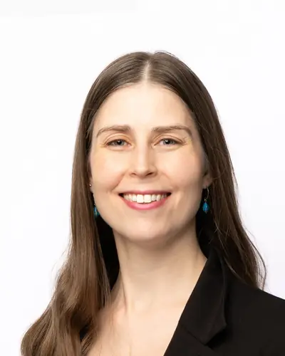 Team member in a black blazer over teal
