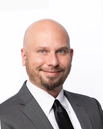 Team member in a grey suit and black tie