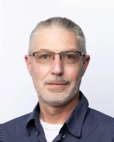 Team member in a navy polo and glasses