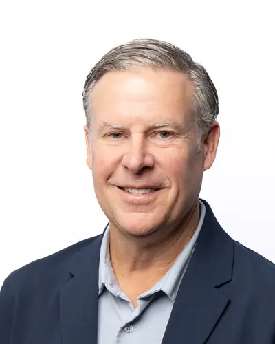 Team member in a navy blazer and blue shirt