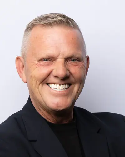 Team member in a dark blazer, arms folded