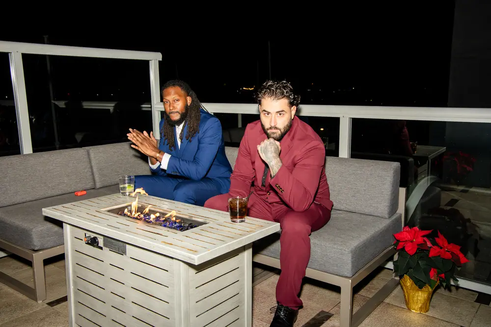 Two guests on the Sky Level terrace beside a lit fire pit at Shade Hotel Redondo Beach