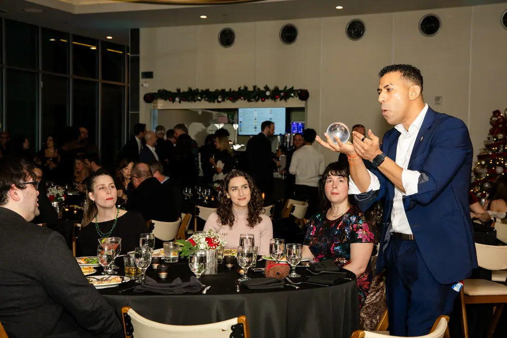 Tableside magic during dinner — the magician working the crystal ball for a seated table